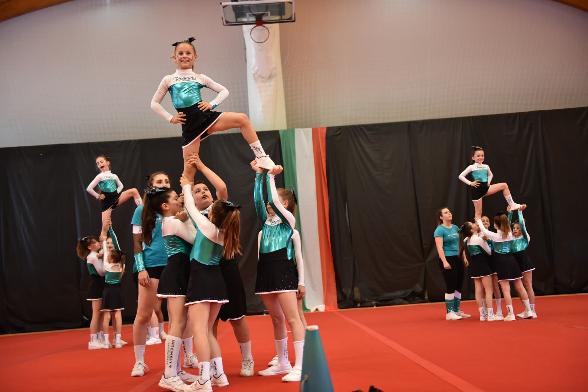 Piccola atleta sollevata in uno stunt del corso tiny