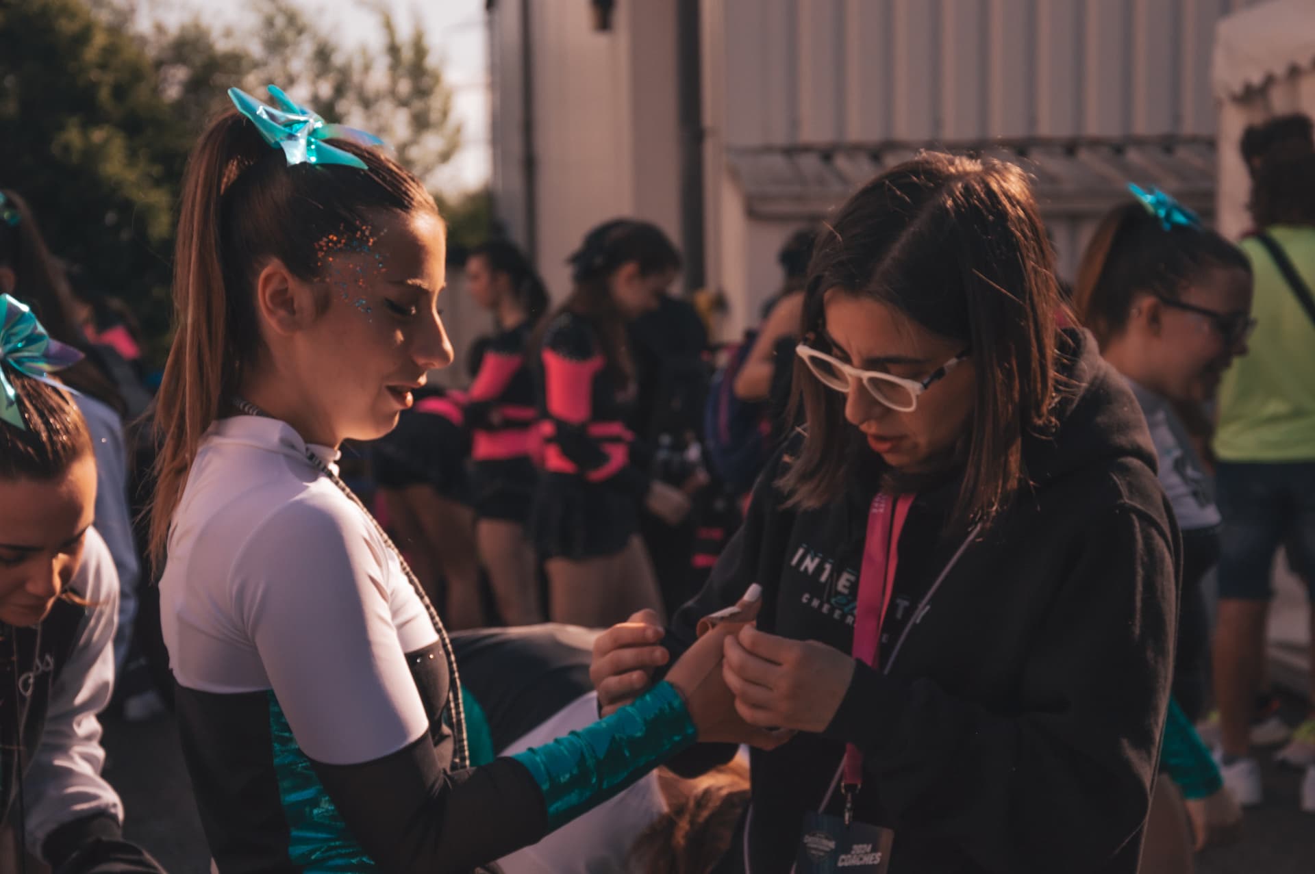 Coach che sistema l'uniforme di un'atleta prima della gara